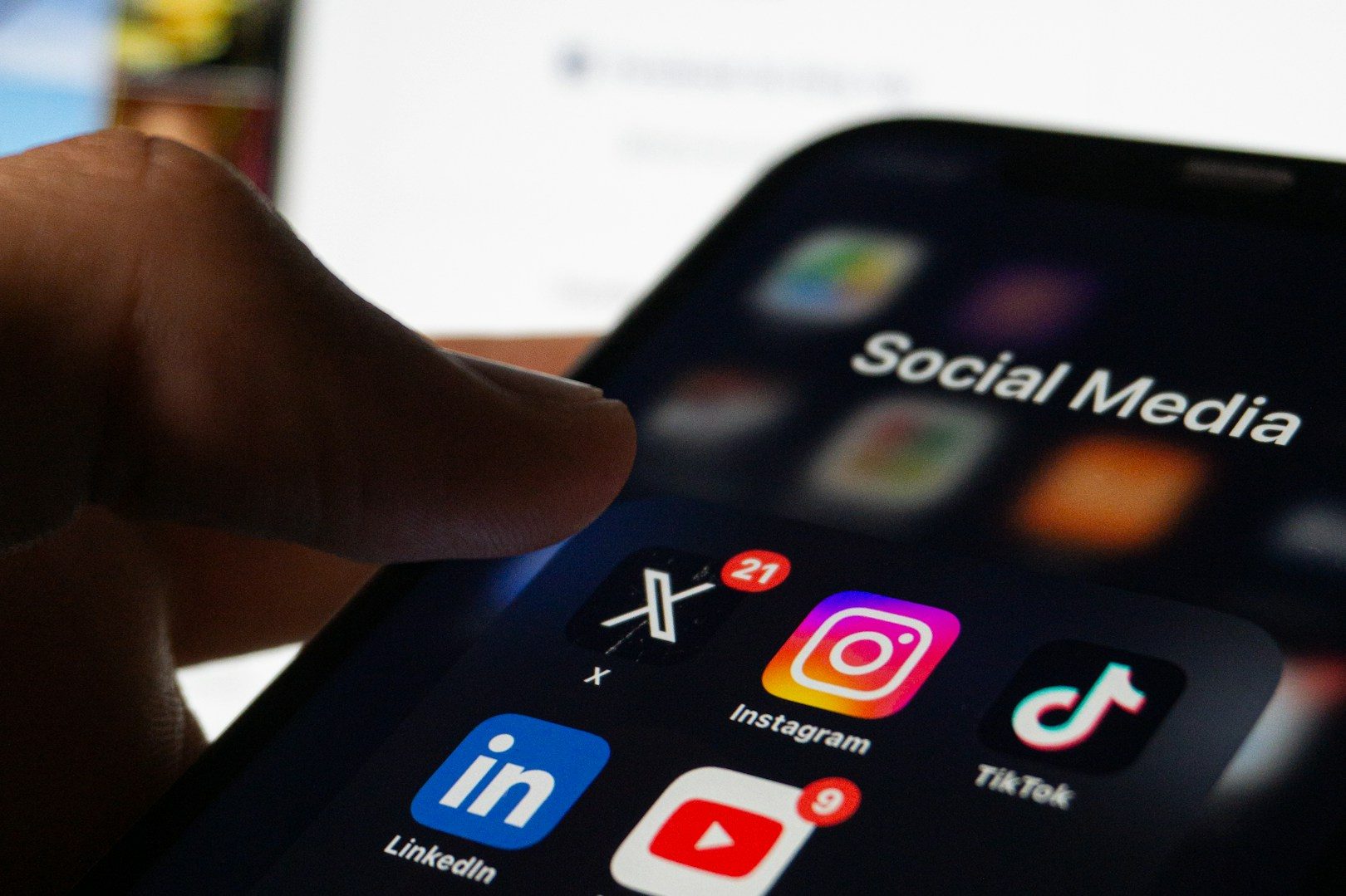 Michelle Bechstein-Ferenz - MBF-Marketing - Social-Media Managerin für KMU Eine Hand tippt auf sozialen Medien-Icons auf einem Smartphone-Bildschirm.